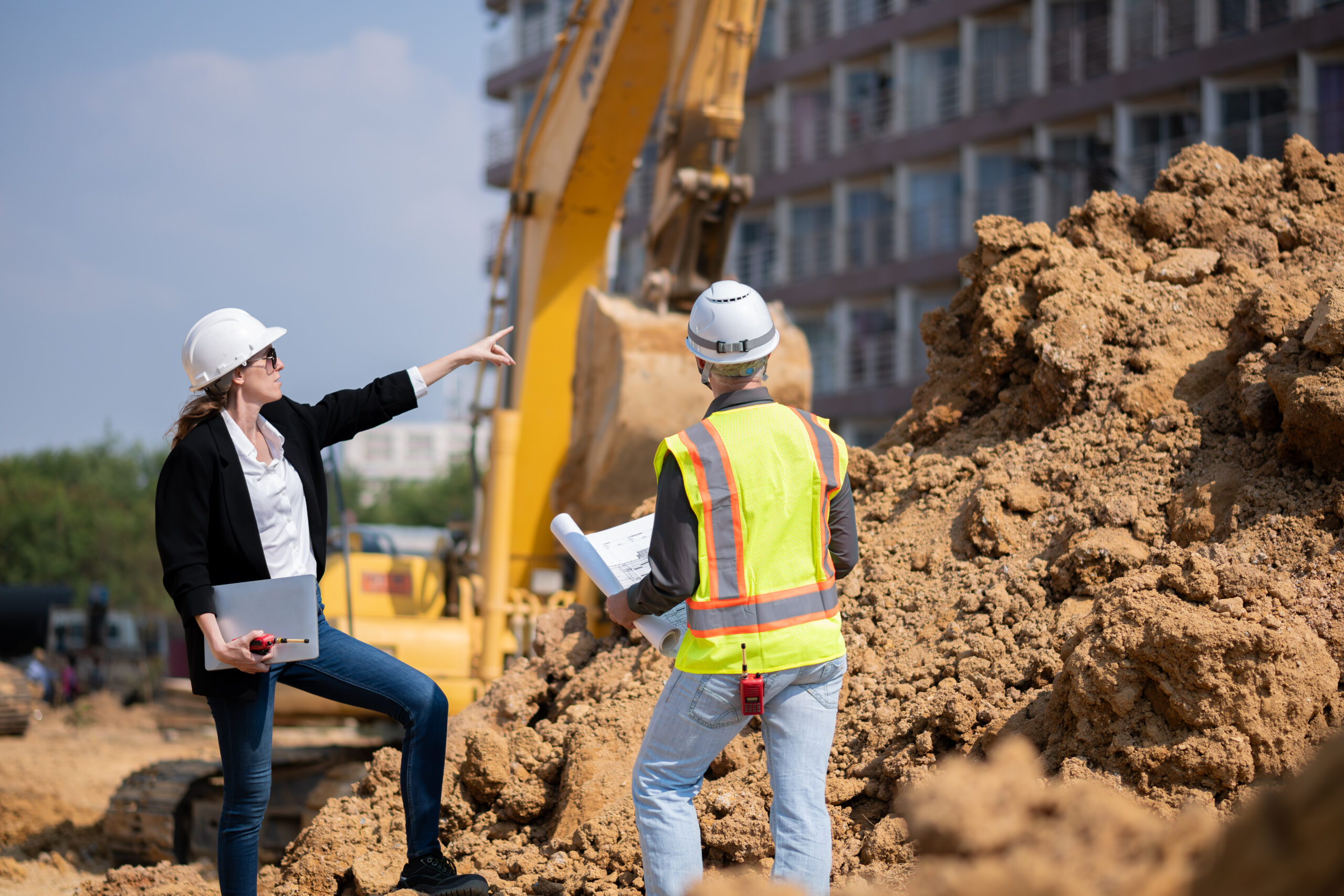 Construction workers discussing plans on-site.