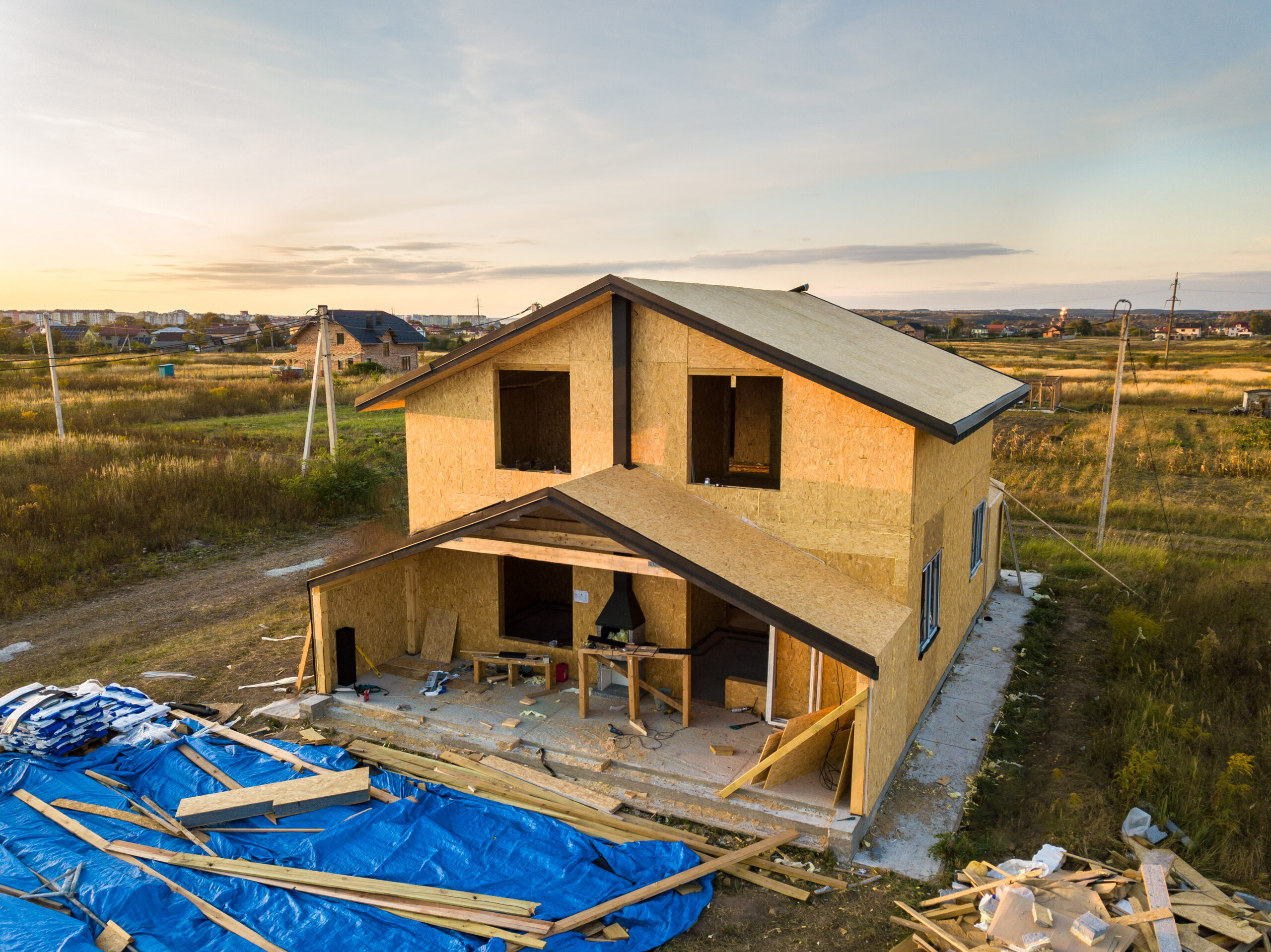 Newly constructed house surrounded by construction materials.